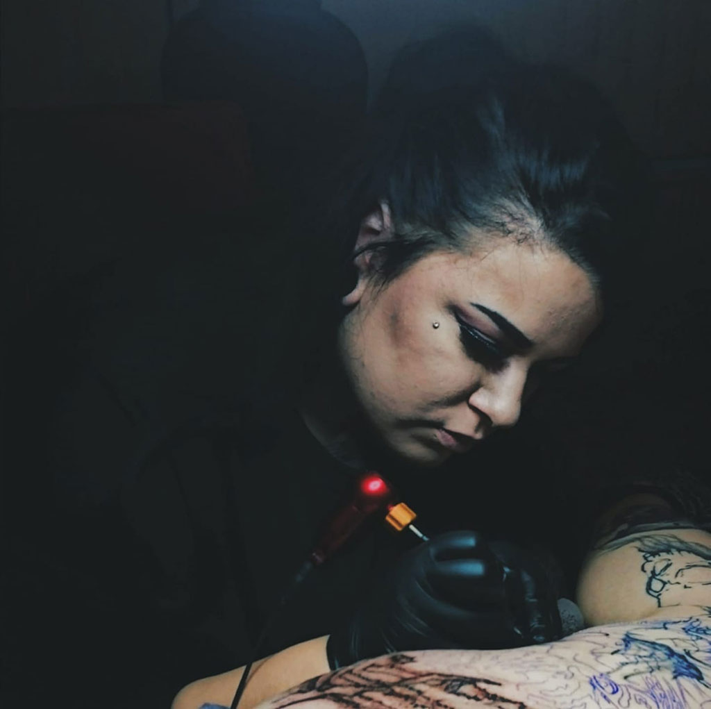 Romie sticht ein Tattoo
